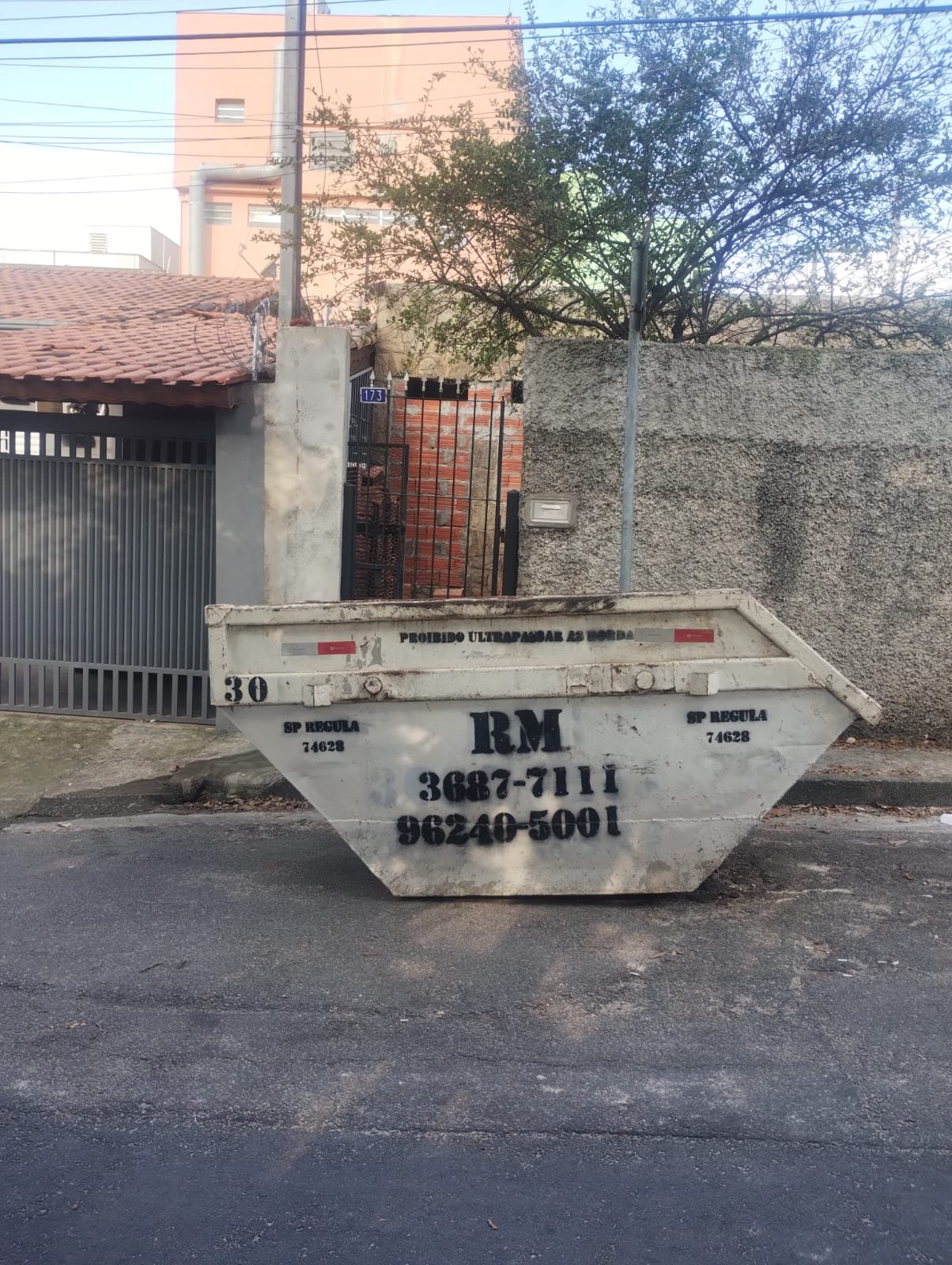 Caçamba RM instalada em frente a um imóvel